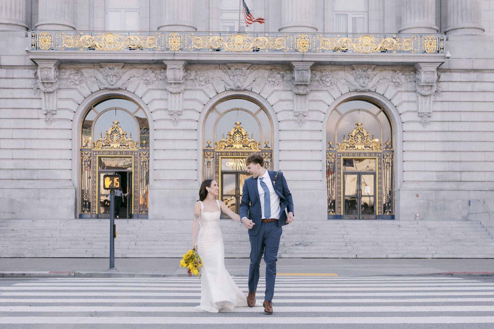 Bride and groom smiling at each up outside San Francisco City Hall